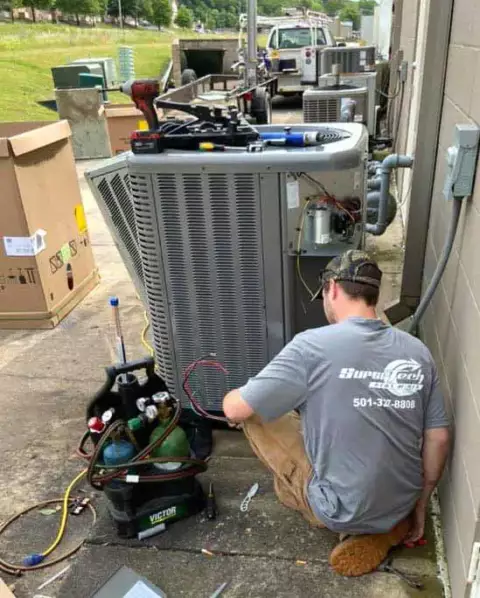 A Super Tech performing preventative maintenance on a customer's air conditioner